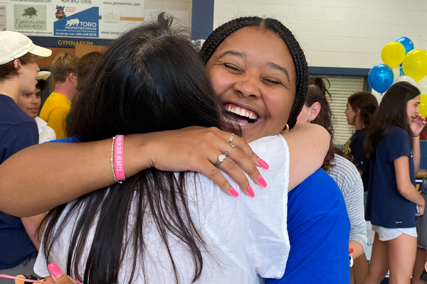 Teacher hugs alum