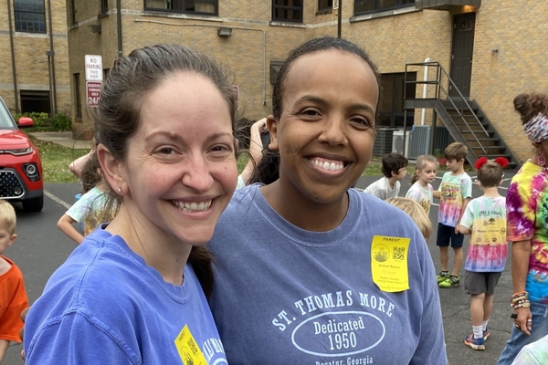 2 parents working field day activity and smiling