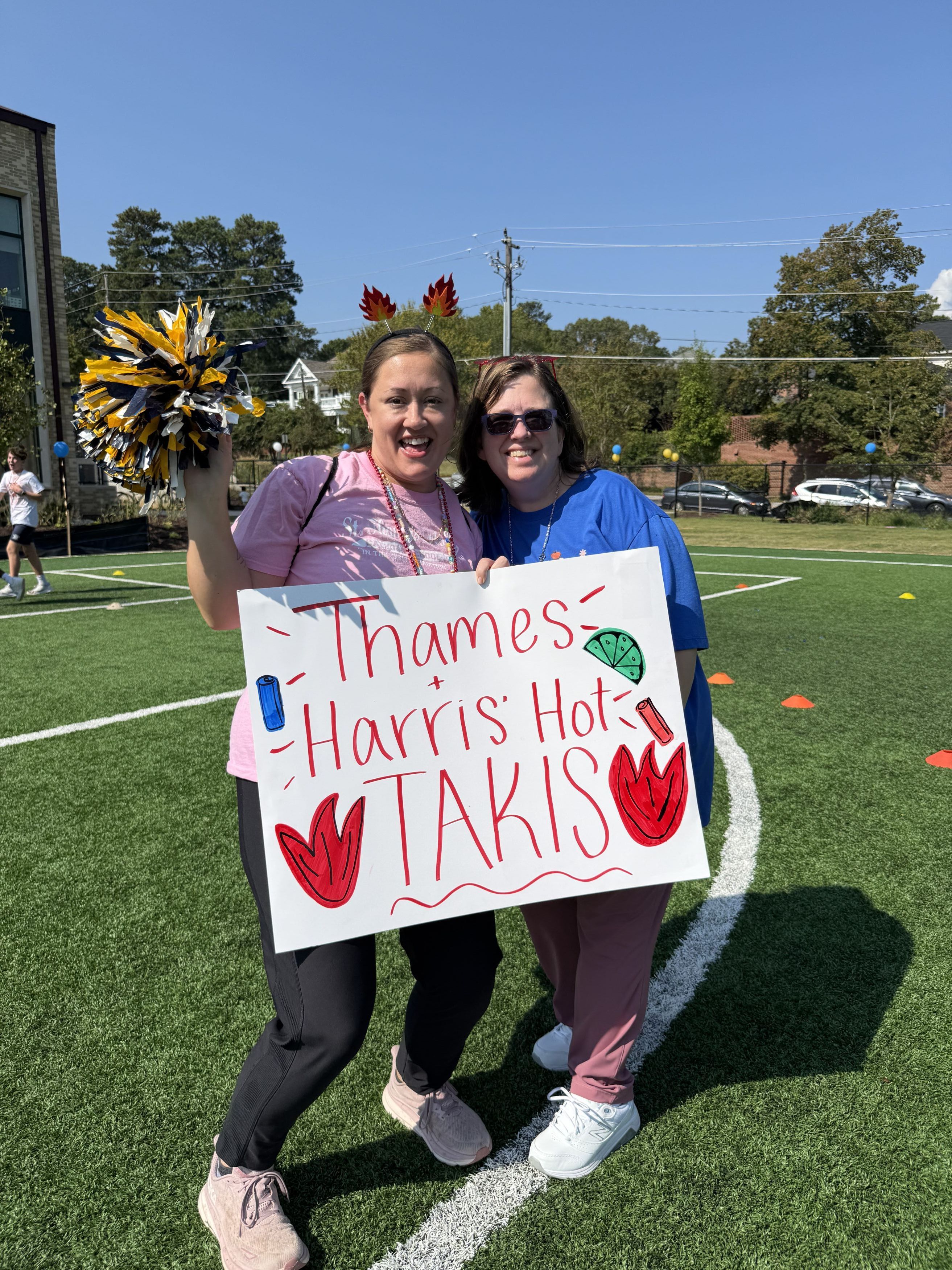 Middle school math teachers Ms. Thames and Ms. Harris cheer on their classes at Rock n Run